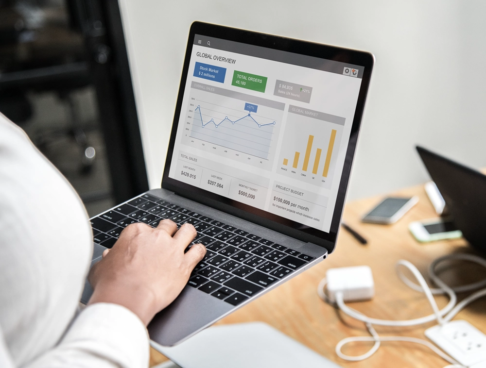 Osoba przy laptopie analizująca dashboard z wynikami kampanii sprzedażowych
